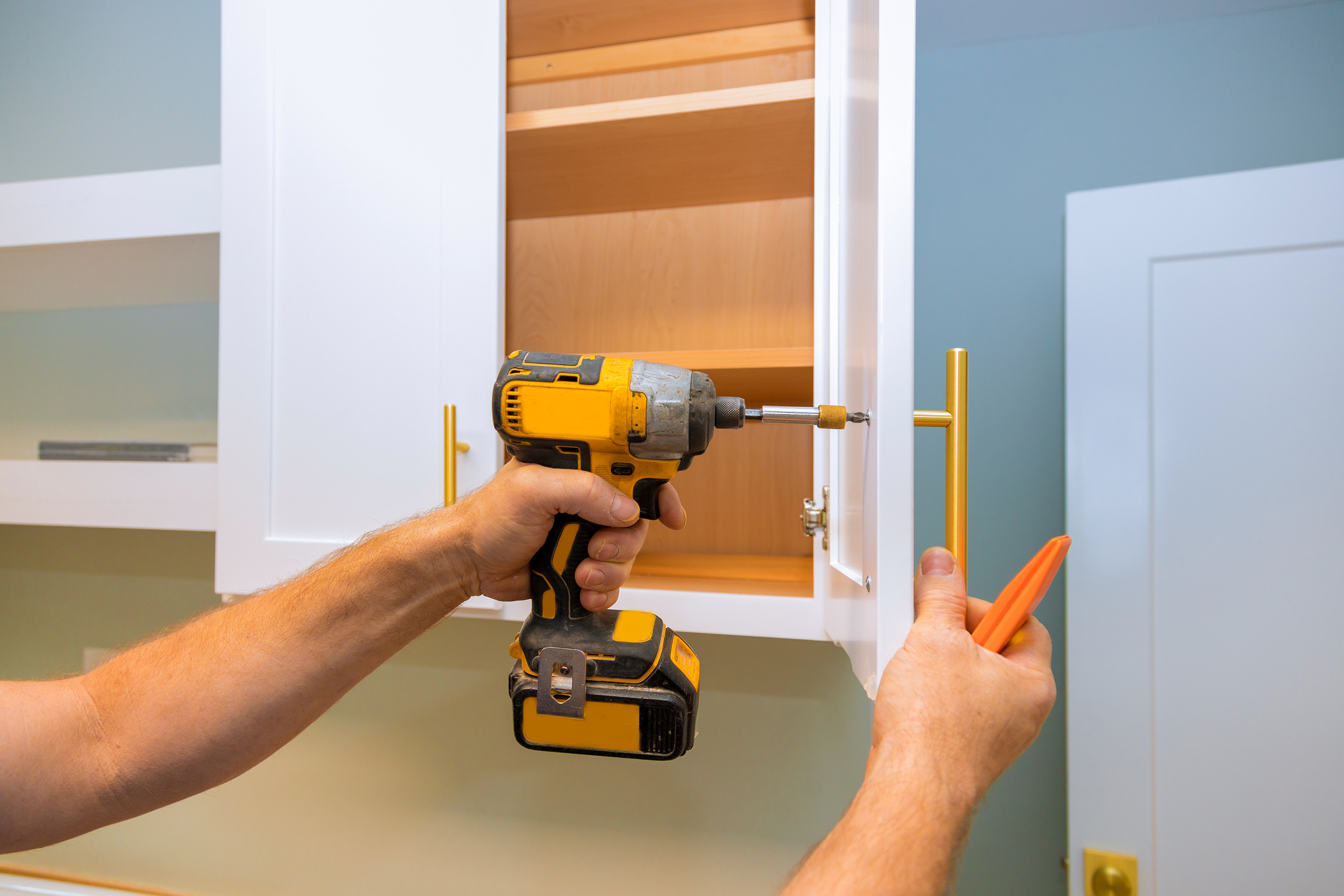 Man Installing New Kitchen Cabinet Door 