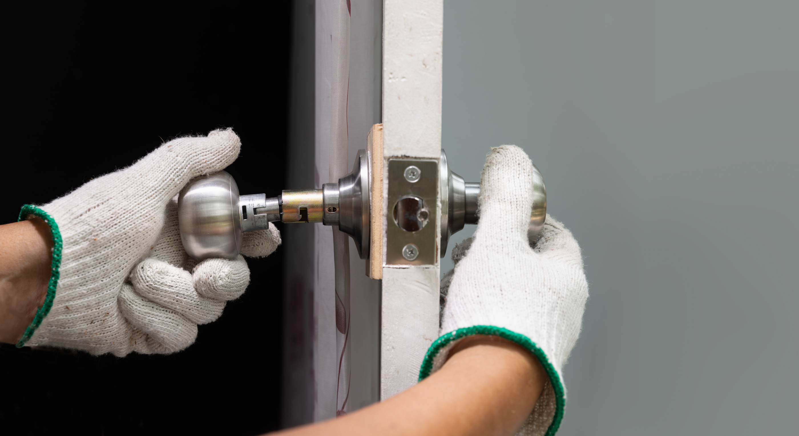 Locksmith repairing a broken door .