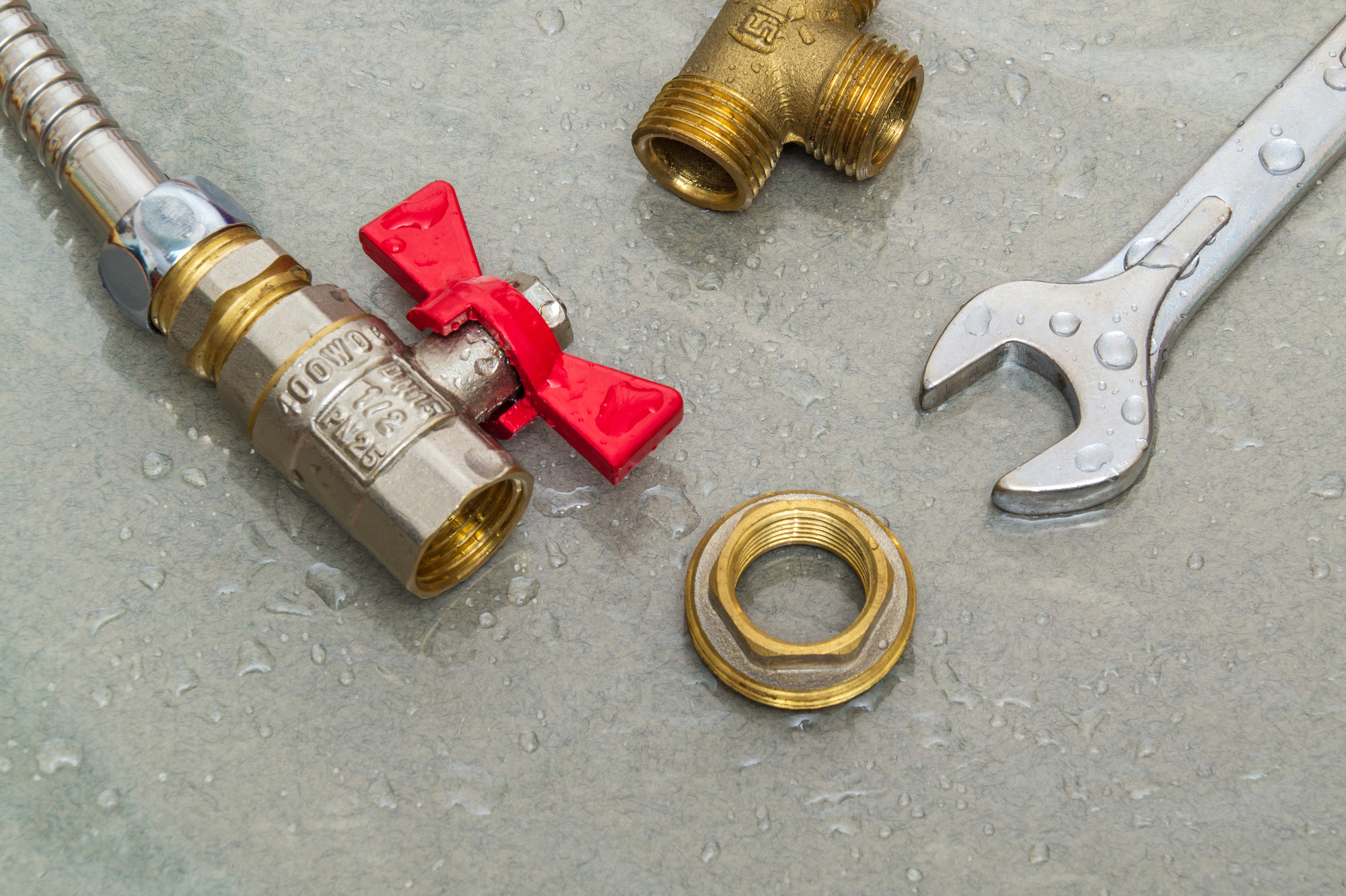 Plumbing faucet and a wrench in water drops during equipment rep